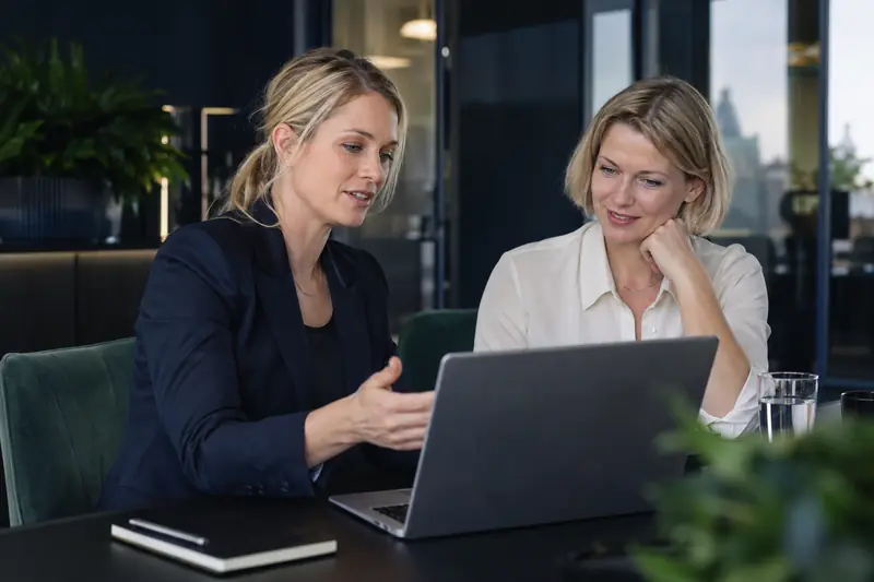 Two colleagues working together on a laptop